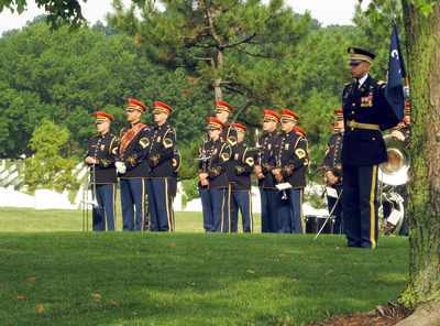 Band plays while casket is loaded onto horse-drawn caission.